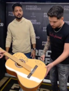 Violão autografado por artistas durante a Expoglória 2025,…